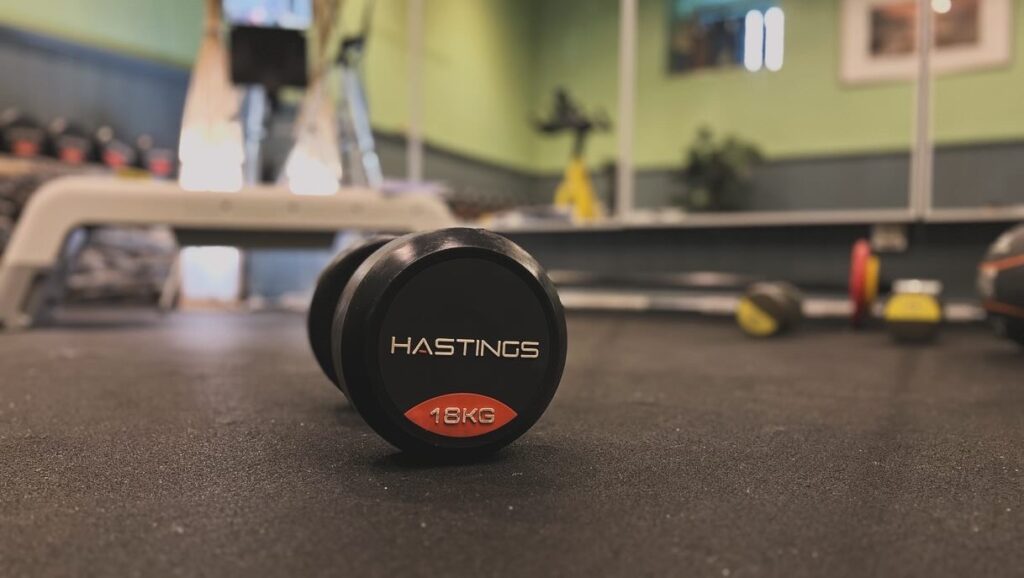A line of professional dumbbells in the David Todd Fitness pT Studio with a slate wall