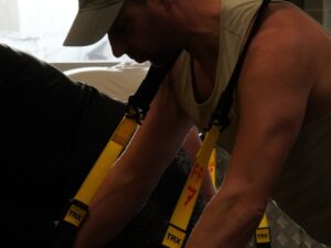 Man over 40 performing TRX row to improve strength and reduce joint pain.
