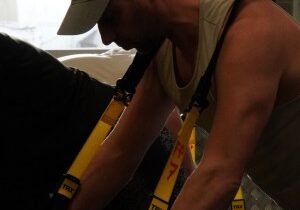Man over 40 performing TRX row to improve strength and reduce joint pain. Let me know if you'd like me to generate this image for you.